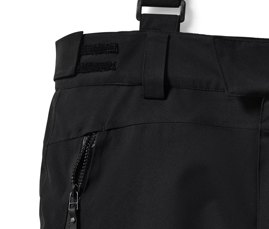 Detailní záběr na černé lyžařské kalhoty High Tech se zipem a šlemi.