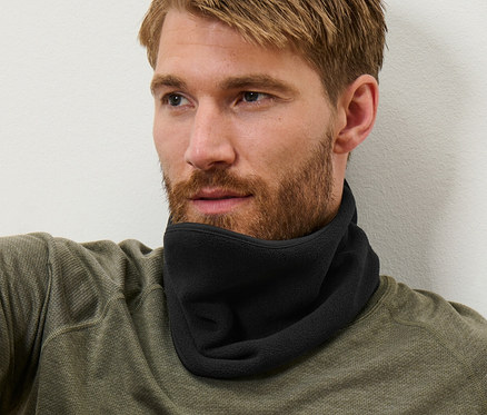 Muž s hnědými vlasy sedí a má na sobě černý fleecový límec.