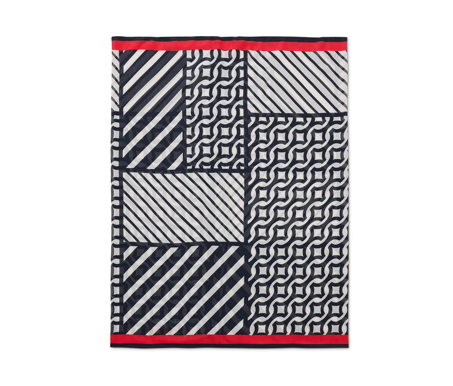 Kruhová šála s potiskem s geometrickými vzory a červeným lemem.