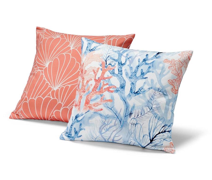 Dva dekorační polštáře: jeden korálový s bílým geometrickým vzorem, druhý s modrými a korálovými korály.