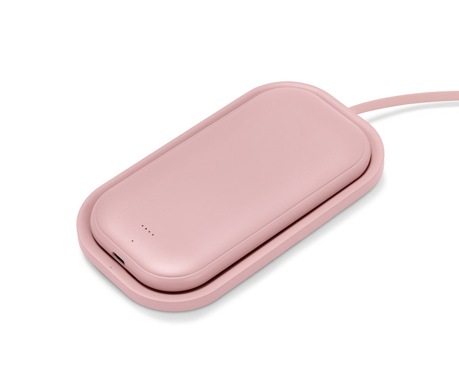 Růžová bezdrátová powerbanka s nabíječkou leží na bílém pozadí.