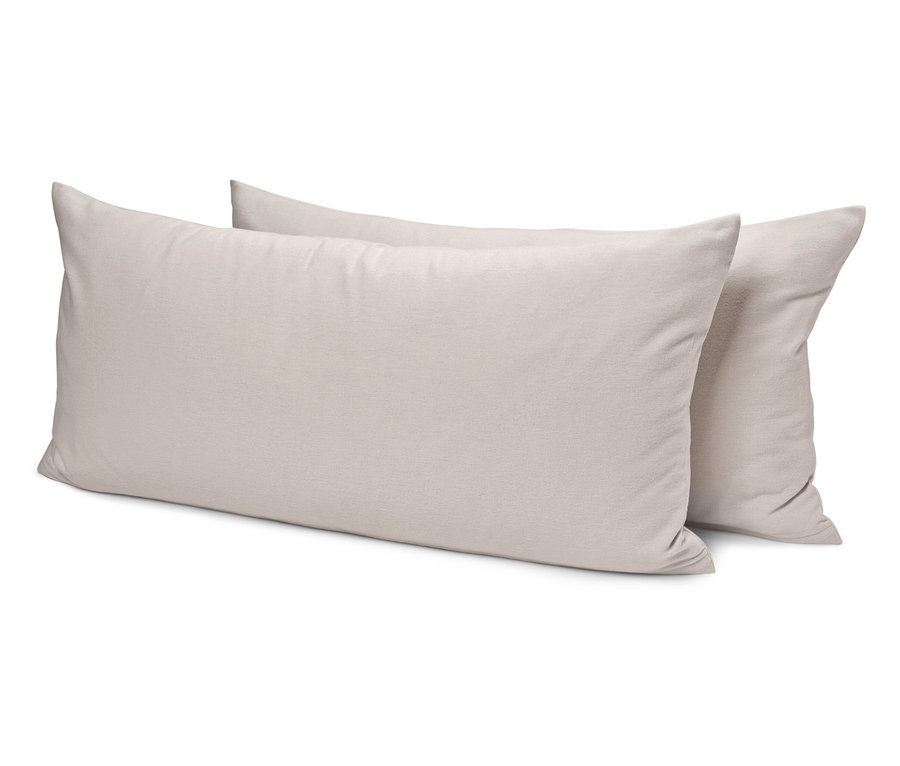 Dva krémové polštáře leží na sobě.