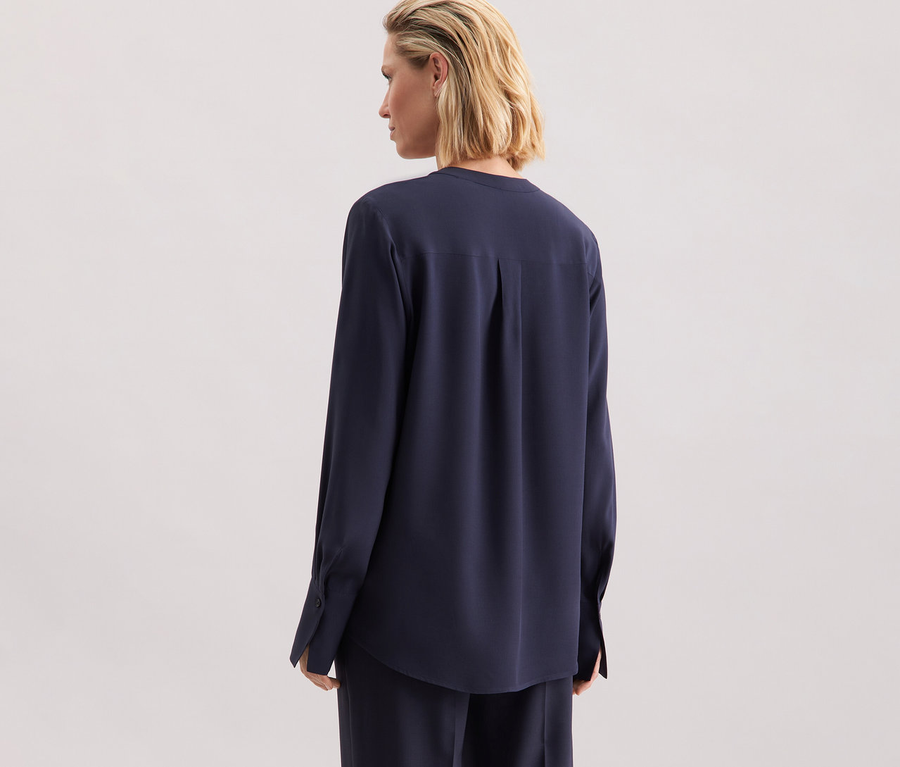 Žena má na sobě tuniku z viskózy Seidensticker, námořnická modrá, pohled zezadu.