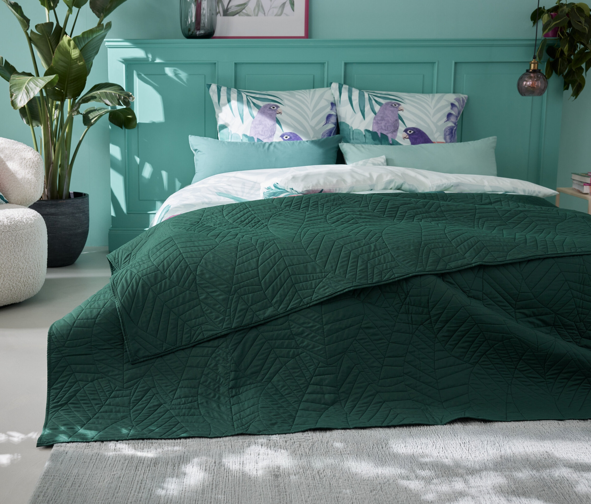 Zelený prošívaný přehoz na postel (230 x 250 cm) leží na posteli v ložnici.