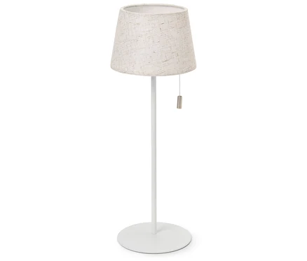 Bílá stojací lampa s béžovým látkovým stínidlem.