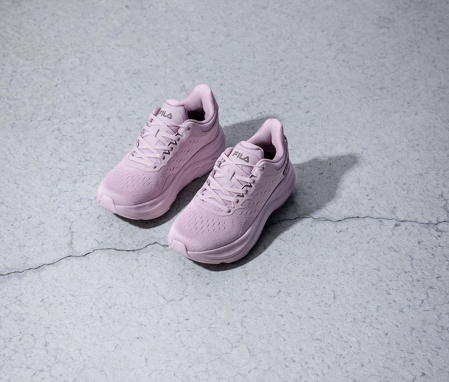 Dvě fialové běžecké boty Fila stojí na šedém pozadí.