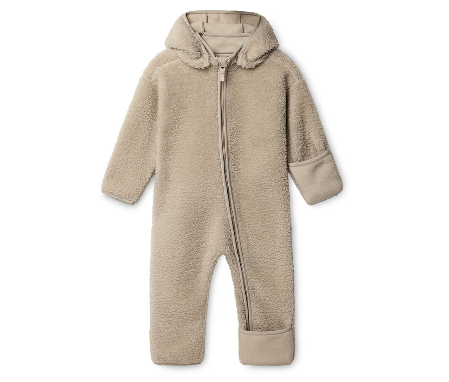 Béžový plyšový overal pro miminka s kapucí a zipem leží na bílém pozadí.