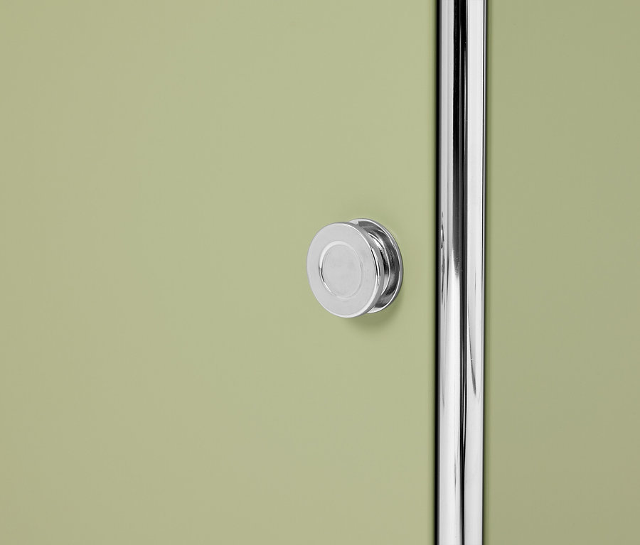 Detailní záběr světle zelených dveří skříňky s kulatým stříbrným knoflíkem a stříbrnou tyčí.