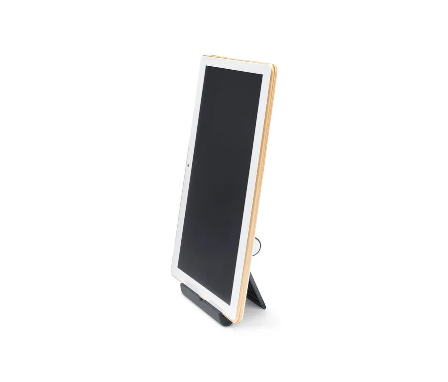 Tablet je umístěn ve černém stojanu na smartphone a tablet.