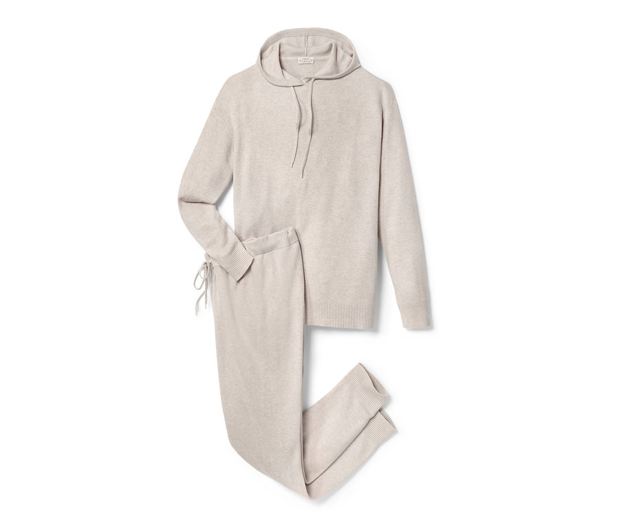 Béžová těhotenská souprava s kapucí a kalhotami leží na bílém pozadí.
