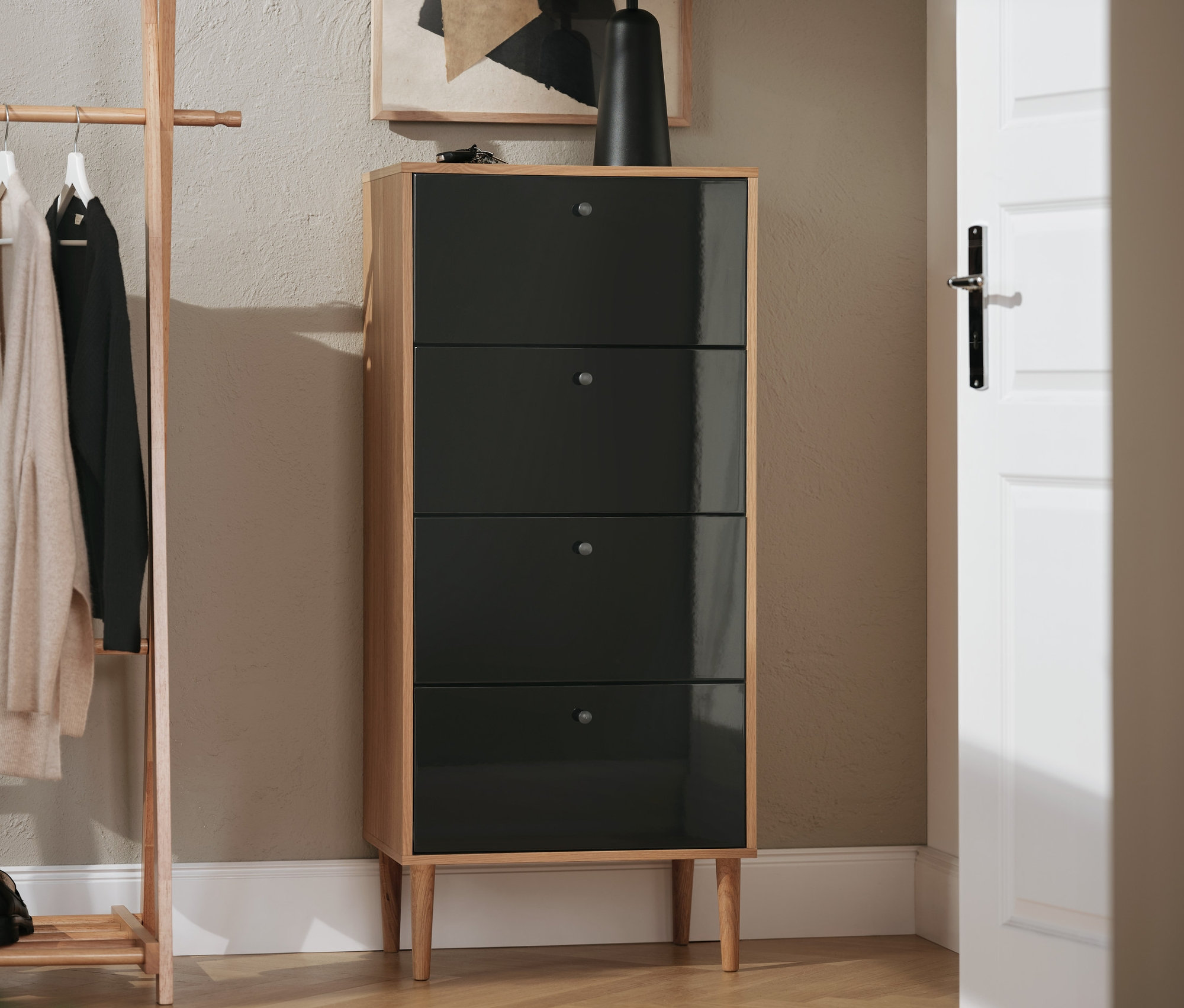 Antracitová úzká komoda Bekeson se čtyřmi zásuvkami v interiéru.