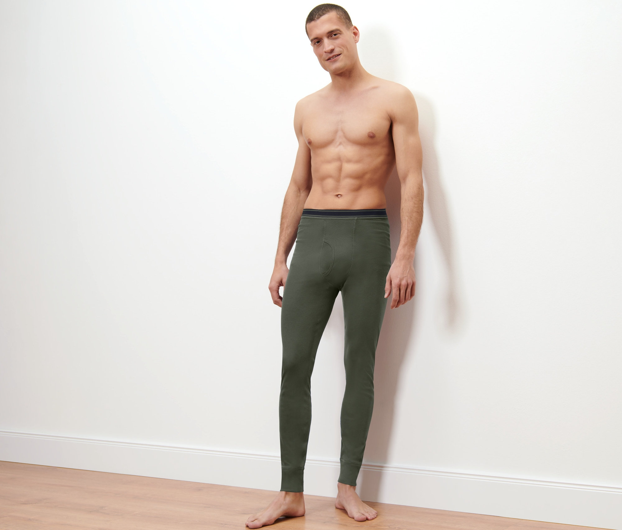 Muž pózuje na světlém pozadí a má na sobě funkční termospodky.