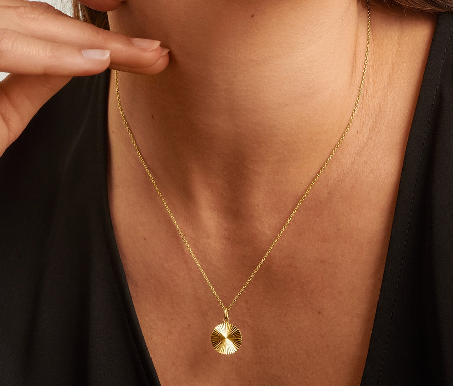 Žena se stříbrným náhrdelníkem ve tvaru slunce ze stříbra 925 a stříbrnými náušnicemi 925 pyramida.