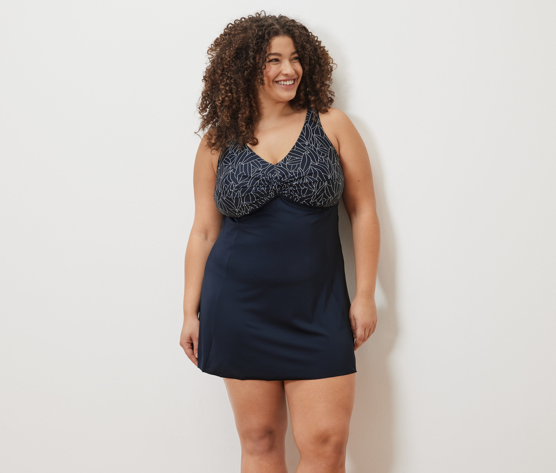 Žena usmívá se a má na sobě plavkové šaty.