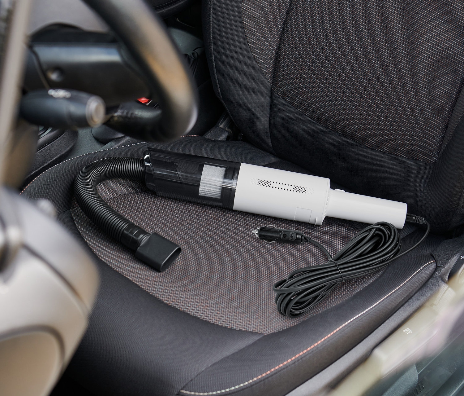 Vysavač do auta leží na sedadle auta.