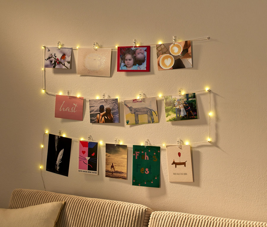 Fotografie ukazuje LED světelný řetěz se svorkami, na kterém visí fotografie.
