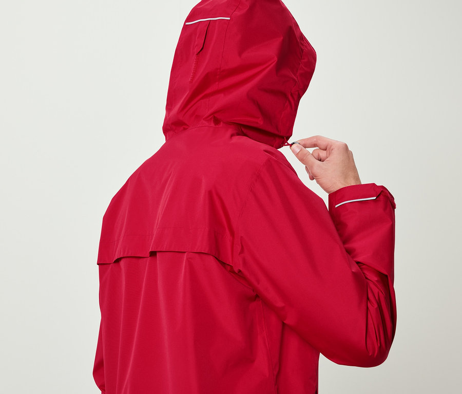 Muž v červené bundě si upravuje kapuci.
