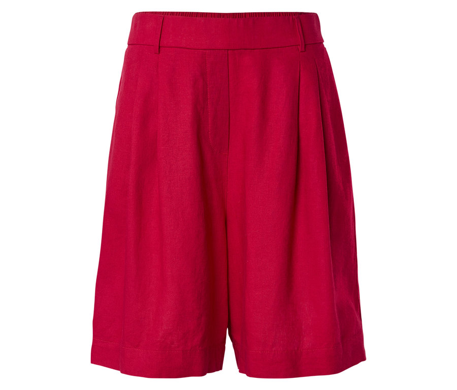 Detail červených šortek se záhyby na bílém pozadí.