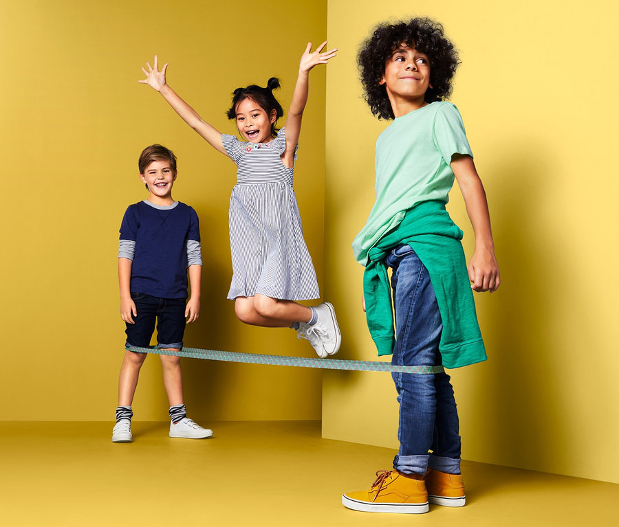 Tři děti si hrají se skákací gumou.