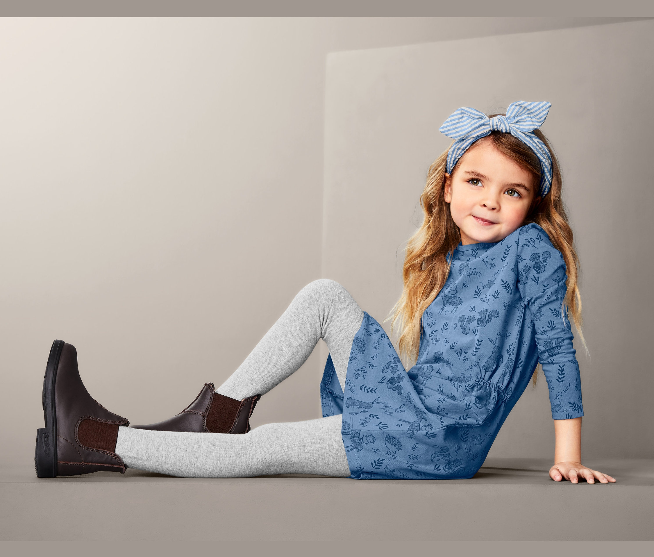 Dívka sedí a má na sobě dresové šaty.