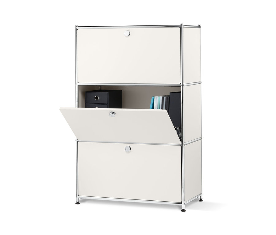 Bílý kovový regál se 3 výklopnými dvířky, jedny dvířka jsou otevřené.