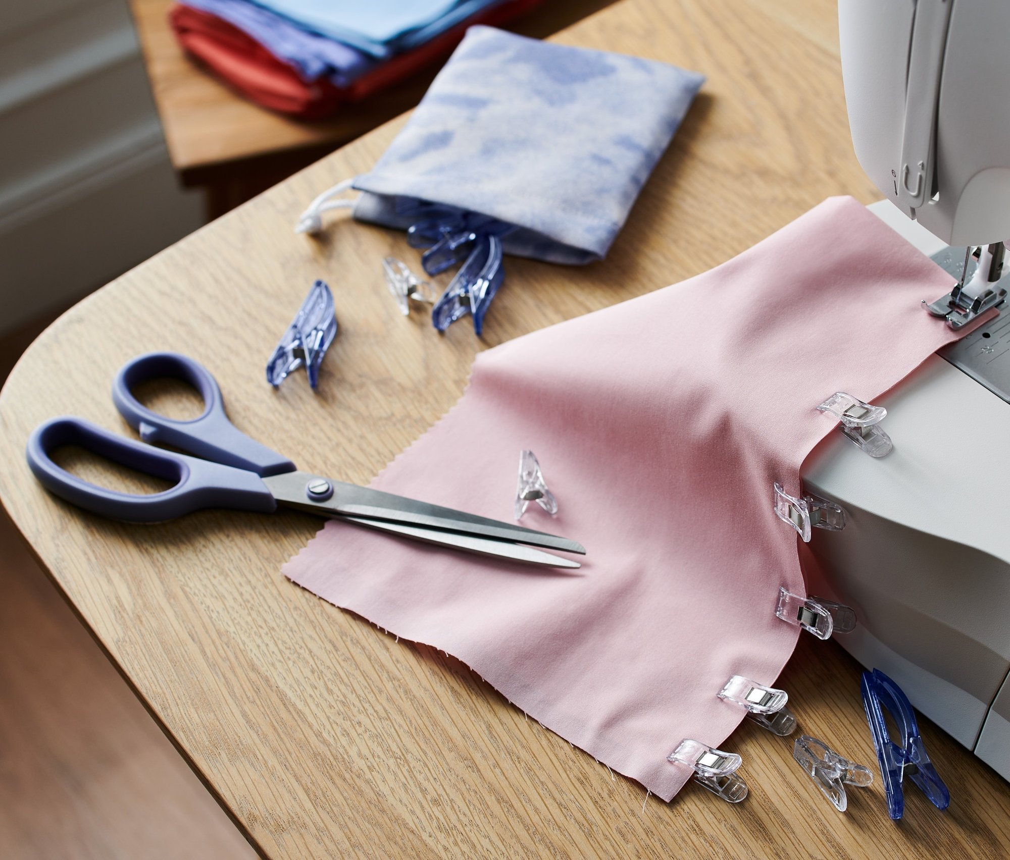 Růžová látka se svorkami na látky, 20 ks, na šicím stroji.