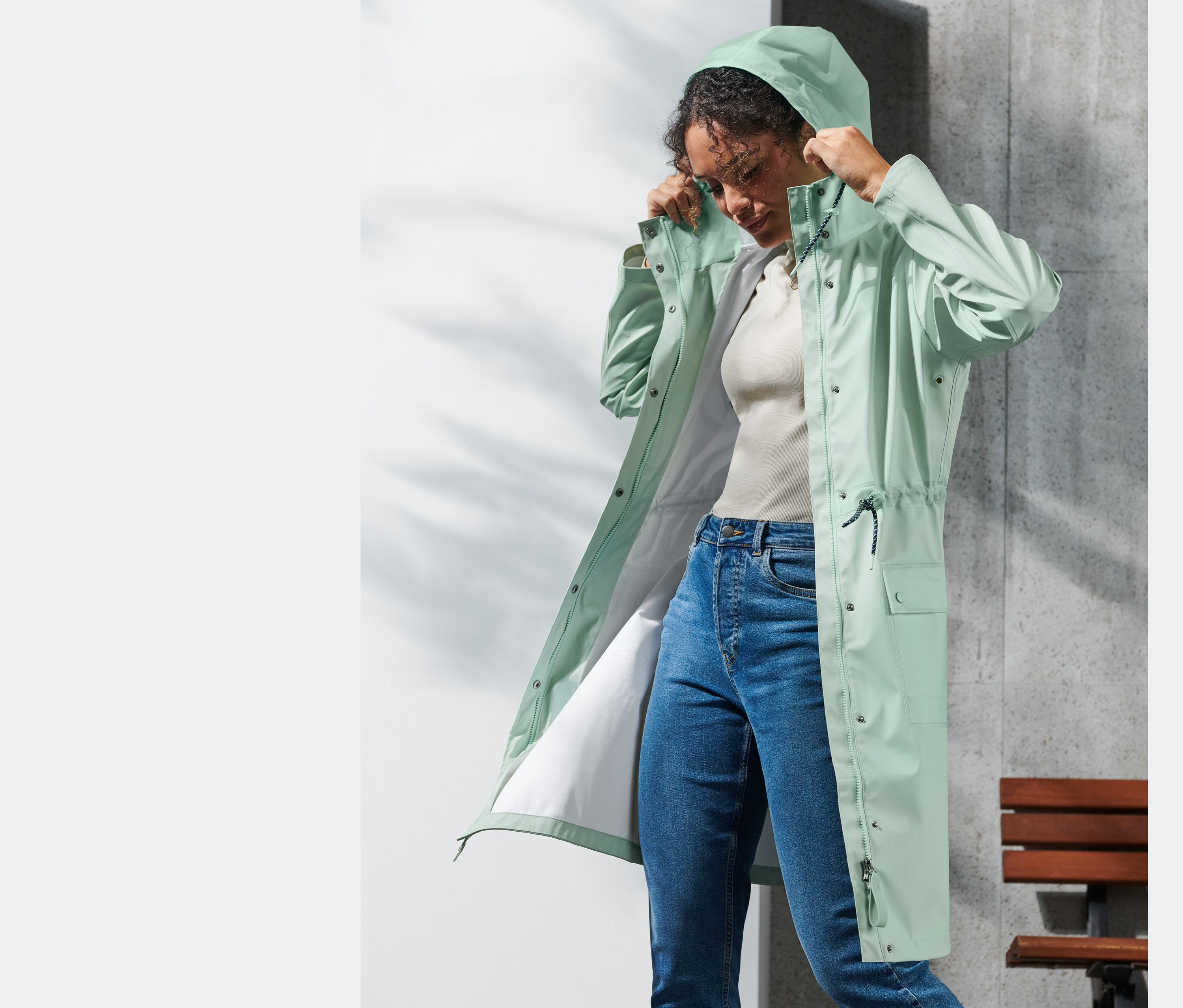 Žena si upravuje kapuci parky do deště.