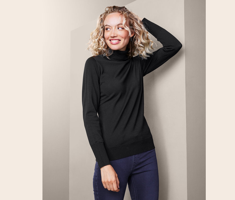 Žena s blond kudrnatými vlasy v černém roláku.