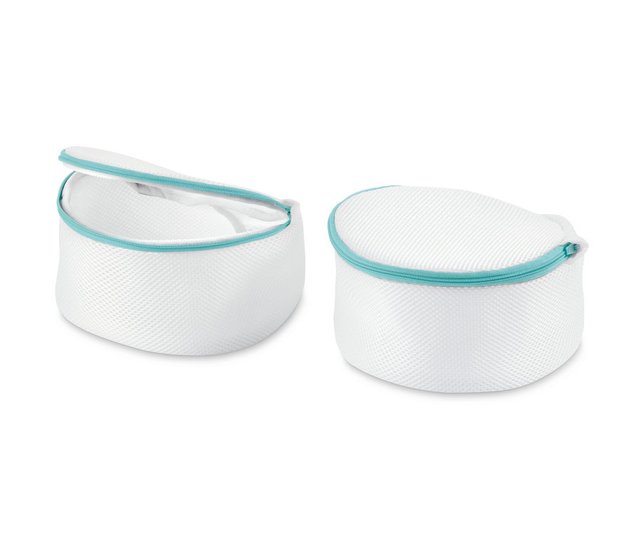 Dva bílé košíčky na praní podprsenek s tyrkysovým zipem.
