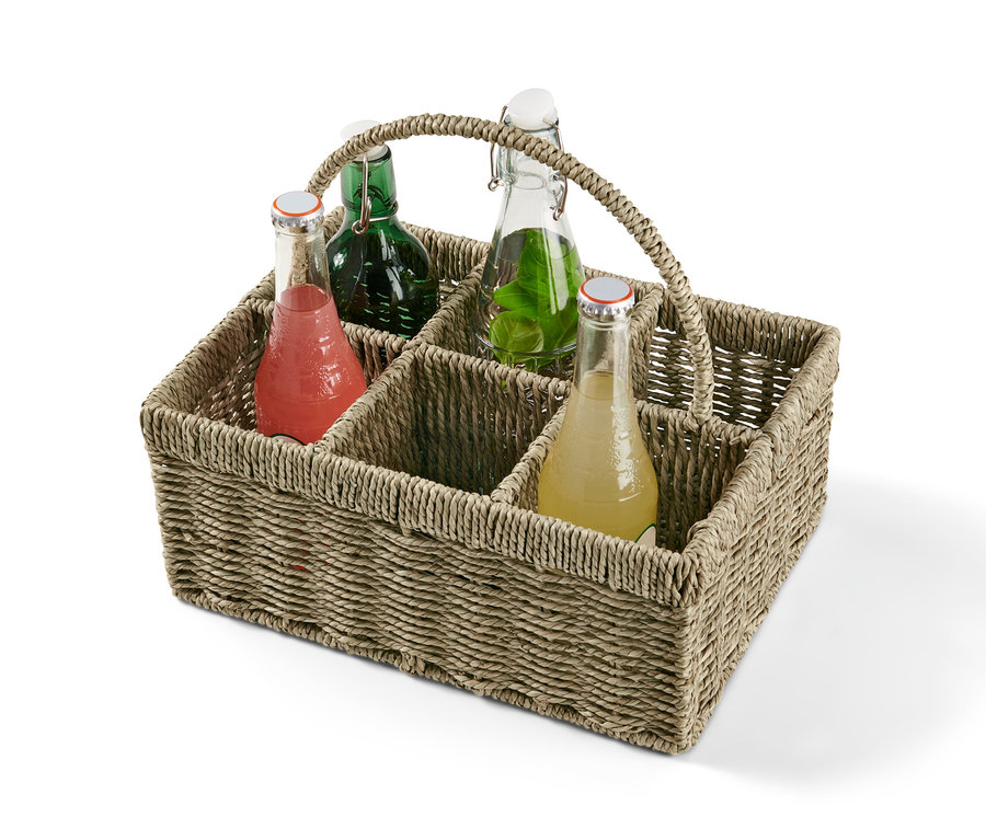 Proutěný košík na láhve se čtyřmi různými barevnými nápoji.