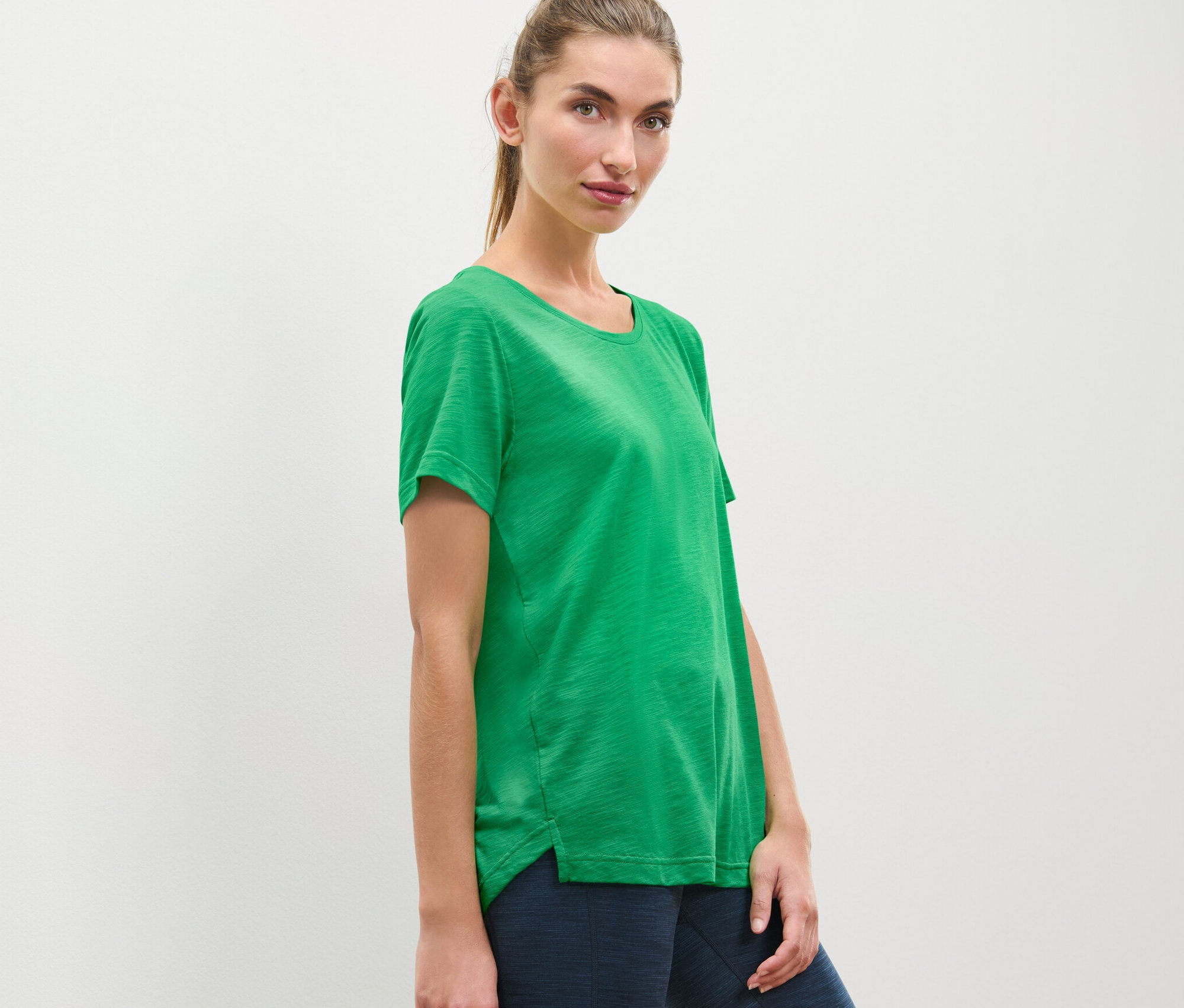 Žena pózuje ve sportovním tričku.