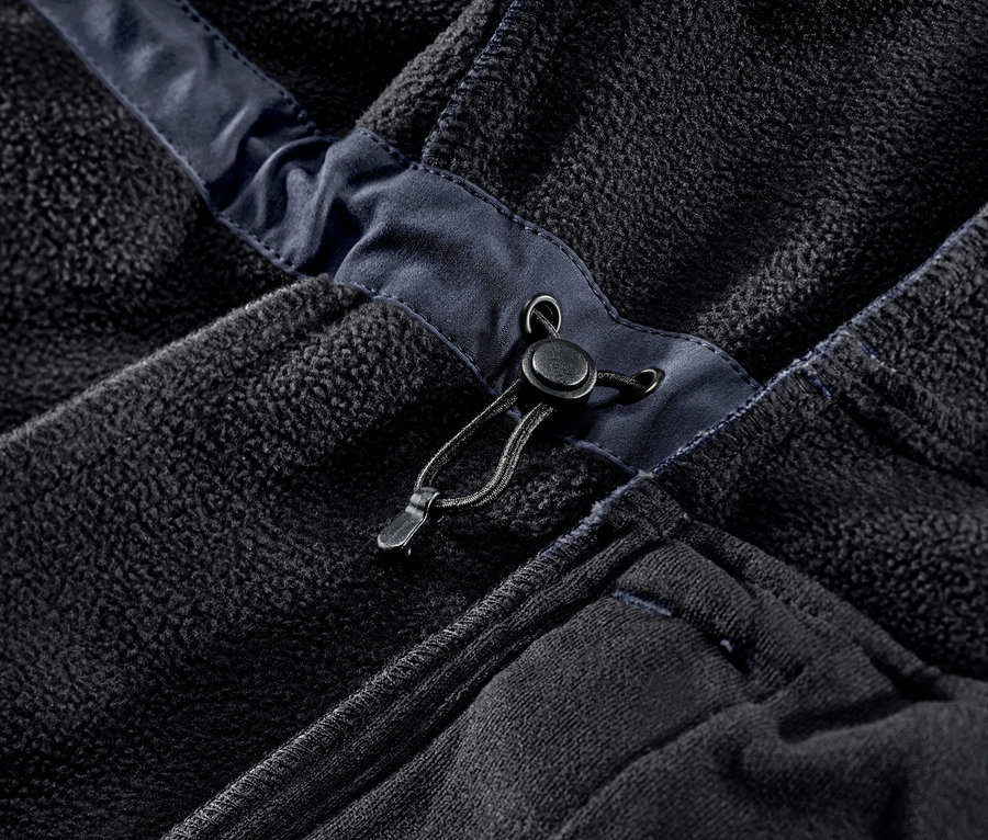 Detail modrého softshellového kabátu.