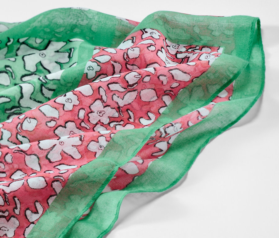 Detail kruhové šály s potiskem s květinovým vzorem v zelené a růžové barvě.