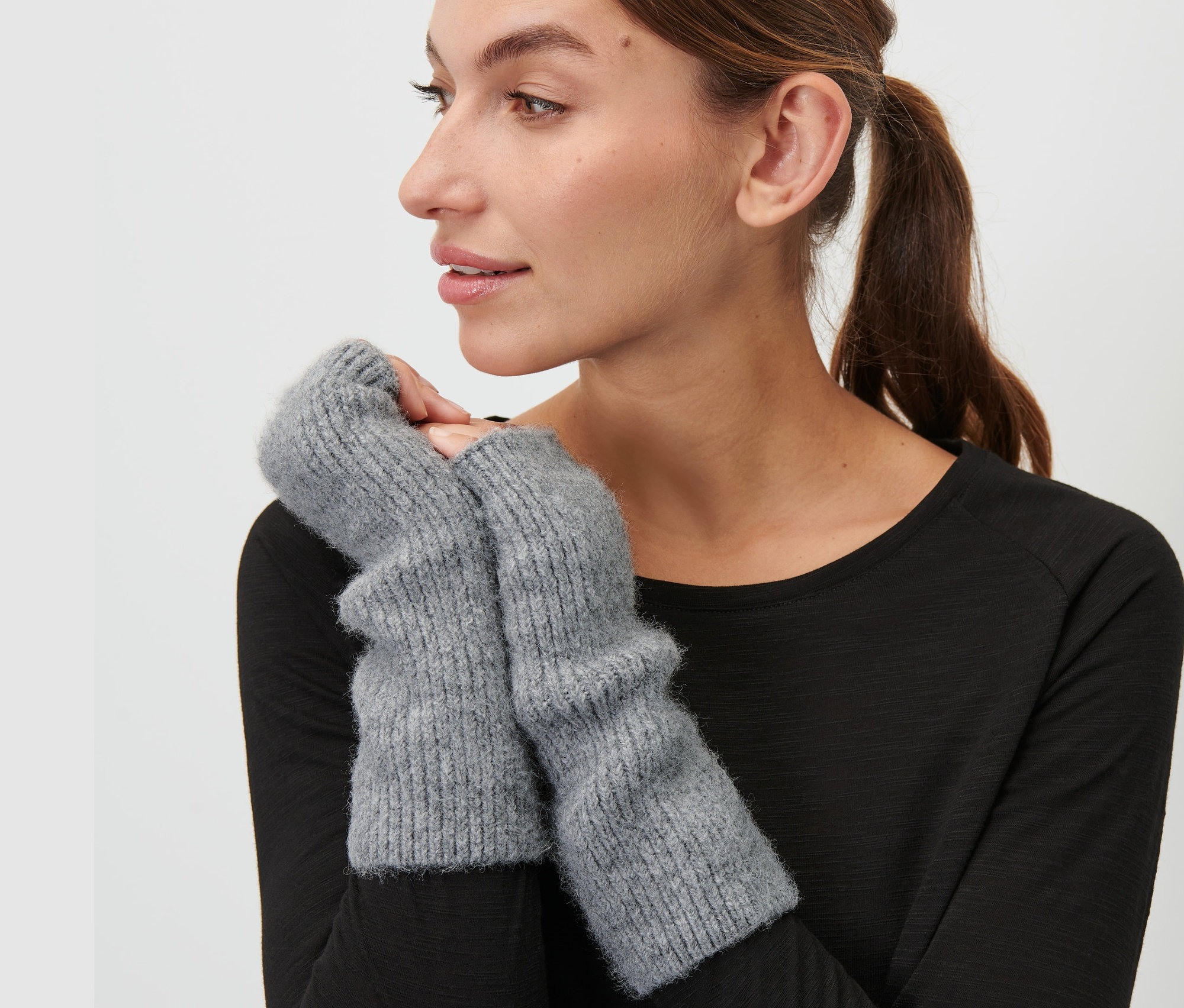 Žena má na sobě šedé návleky na ruce.