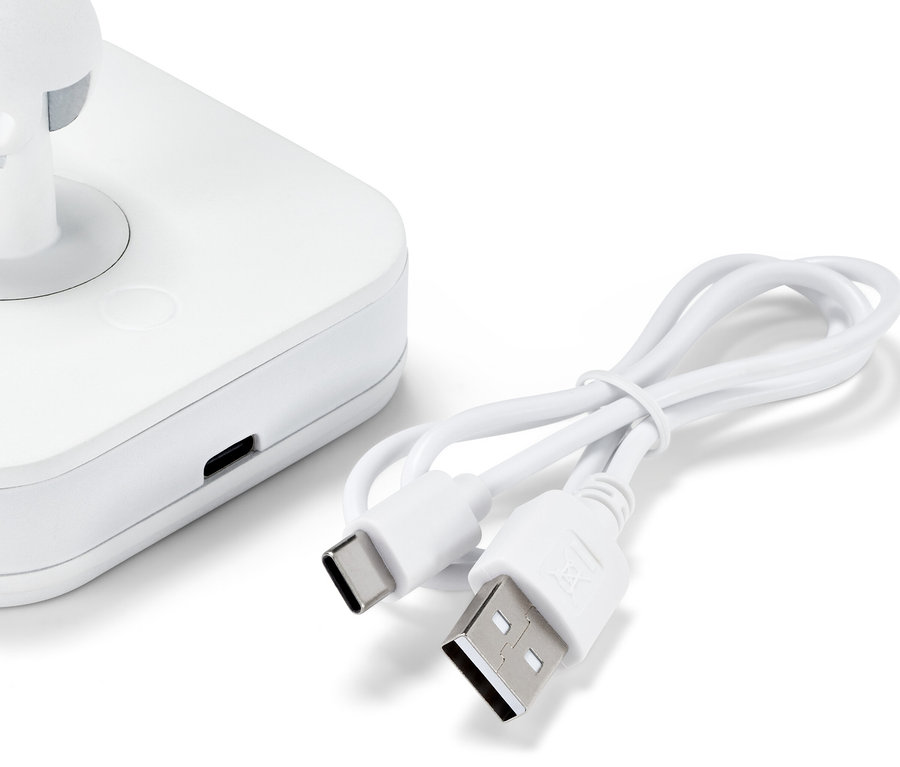 Detailní záběr bílého LED nočního světla s bodovým svítidlem a nabíjecím kabelem.