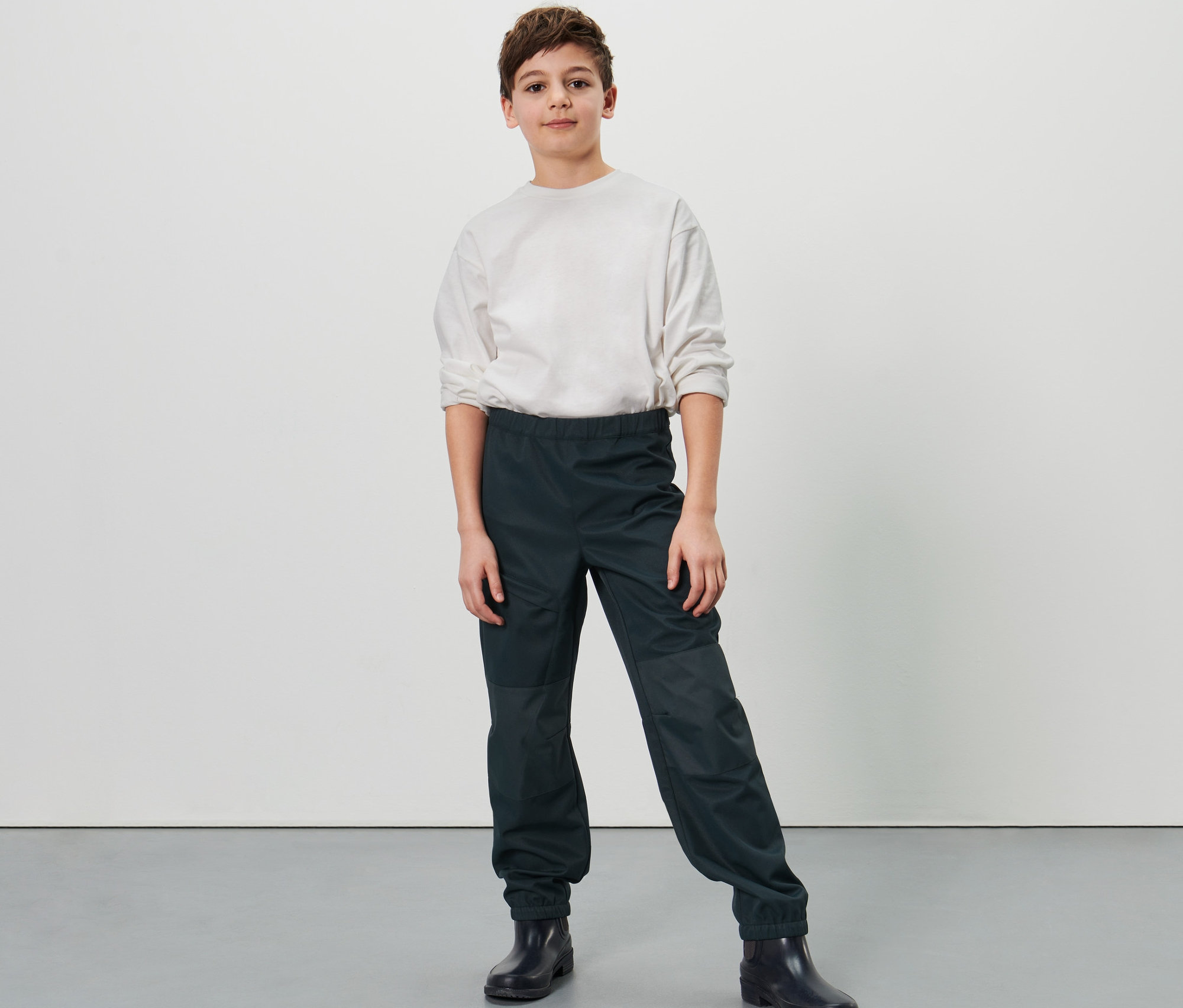 Chlapec pózuje v dětských softshellových kalhotách.