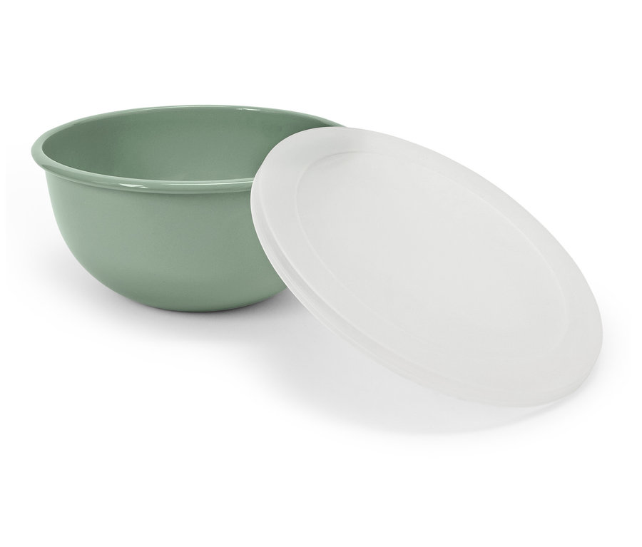 Zelená mísa s bílým víkem leží vedle ní.