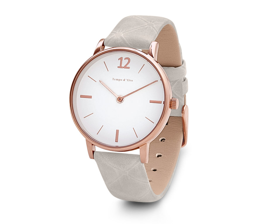 Detailní pohled na náramkové hodinky s koženým řemínkem s bílým ciferníkem a růžově zlatým pouzdrem.