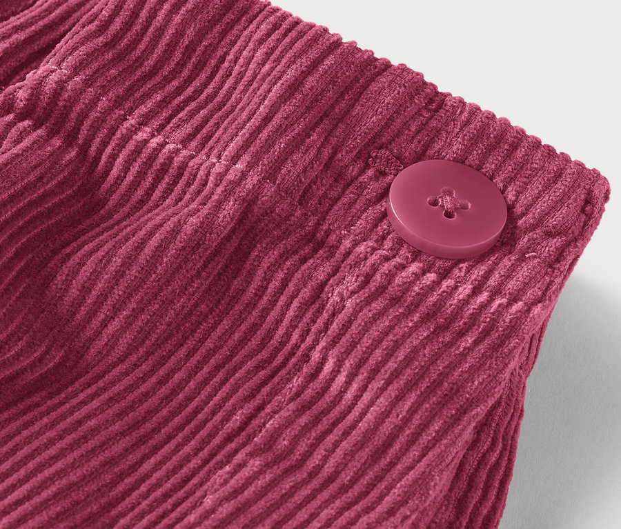 Detail bordó manšestrové látky s knoflíkem.