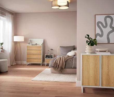 Ložnice s šedou LED stolní lampou na baterie na nočním stolku.