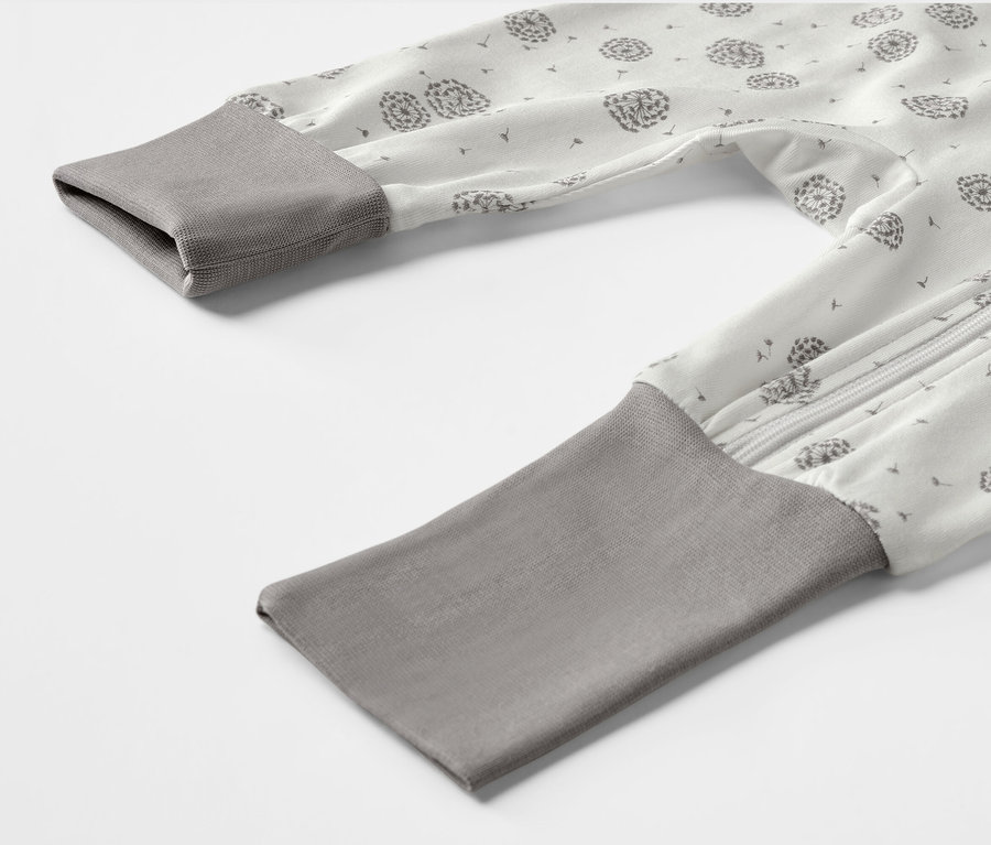 Detail dětského pyžama se vzorem pampelišek.