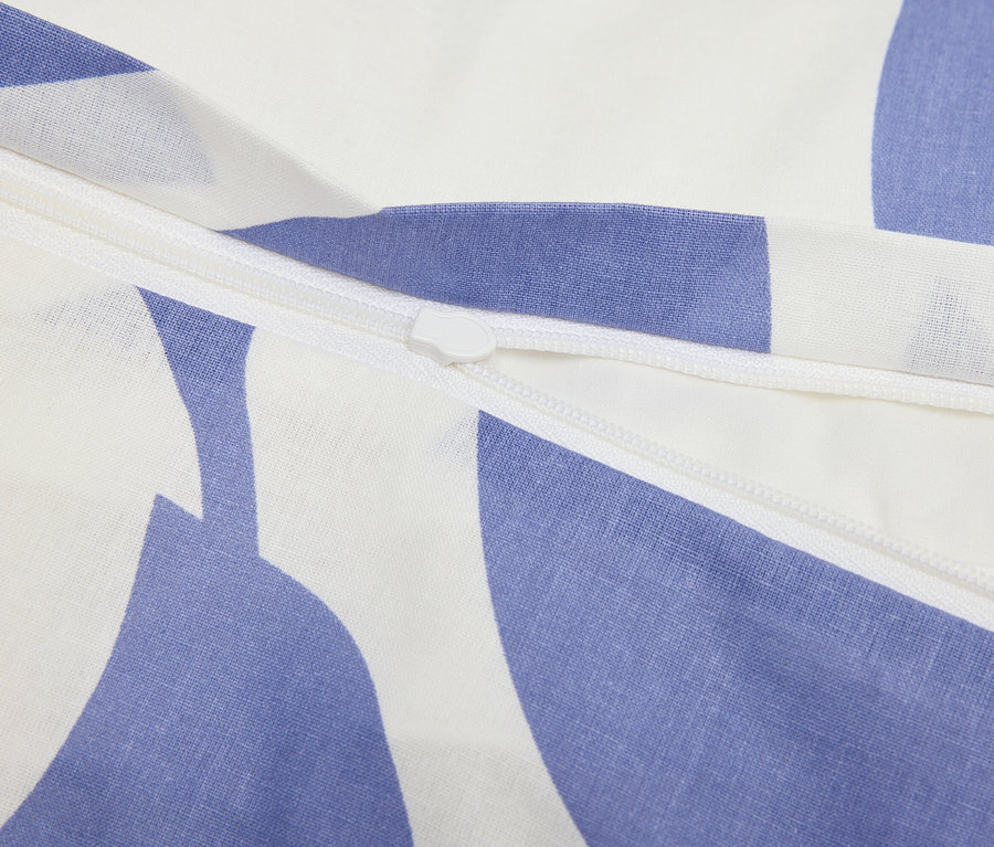 Detail zipu na modrobílé vzorované látce.