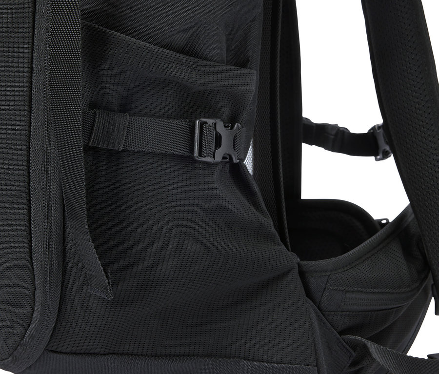 Detailní pohled na černý batoh s boční kapsou a nastavitelným popruhem.