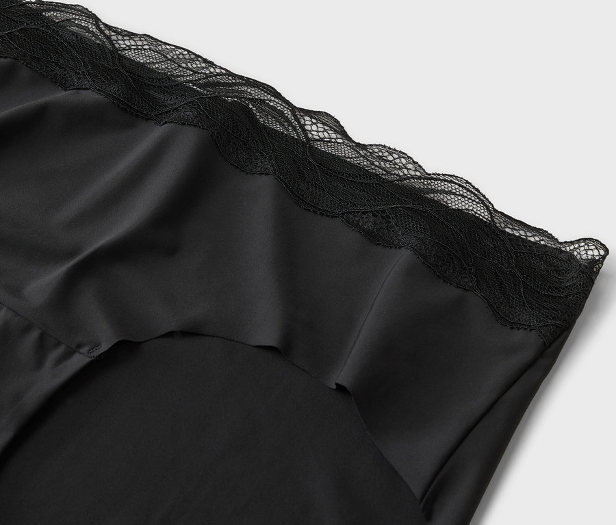 Detailní záběr na černý hedvábný top s krajkovými detaily.