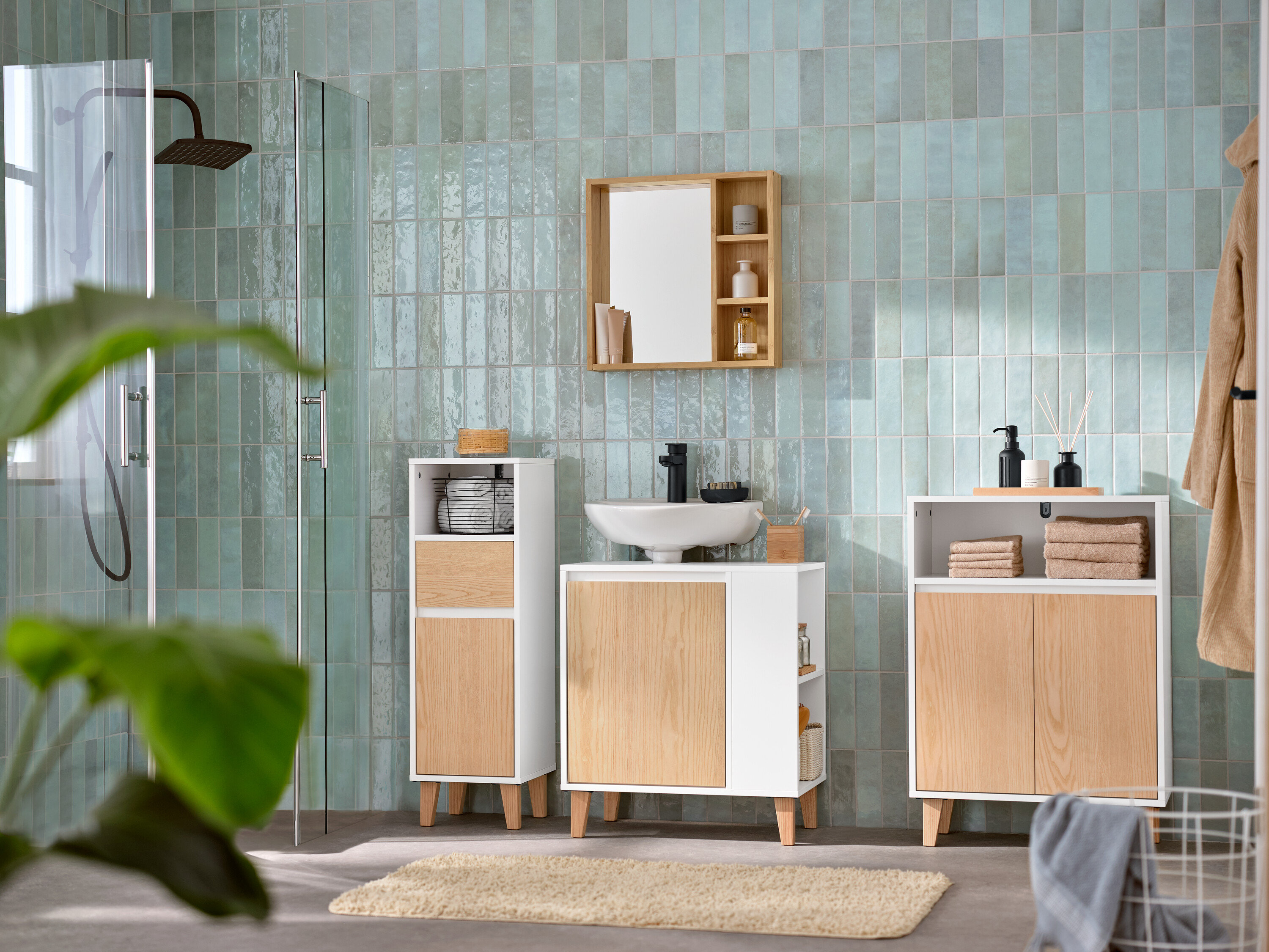 Koupelna s umyvadlovou skříňkou s dvířky a bočním prostorem, zrcadlem s poličkami, odkládací skříňkou se 2 dvířky a otevřeným prostorem a úzkou odkládací koupelnovou skříňkou se zásuvkou a dvířky.