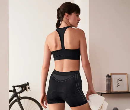 Žena v černém sportovním oblečení má na sobě cyklistické spodky.