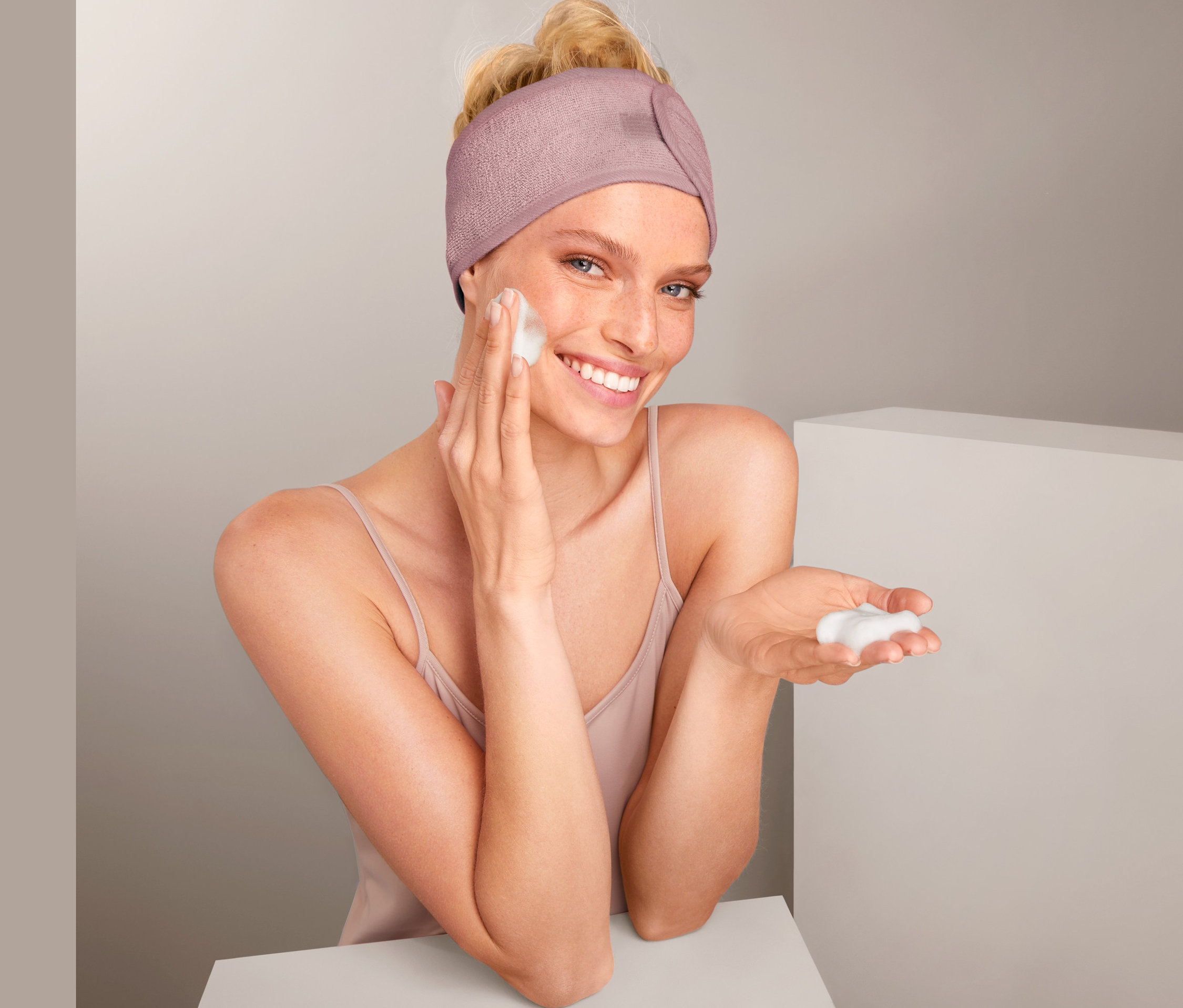 Žena si nanáší pěnu na obličej a má na sobě kosmetickou čelenku, 2 ks.