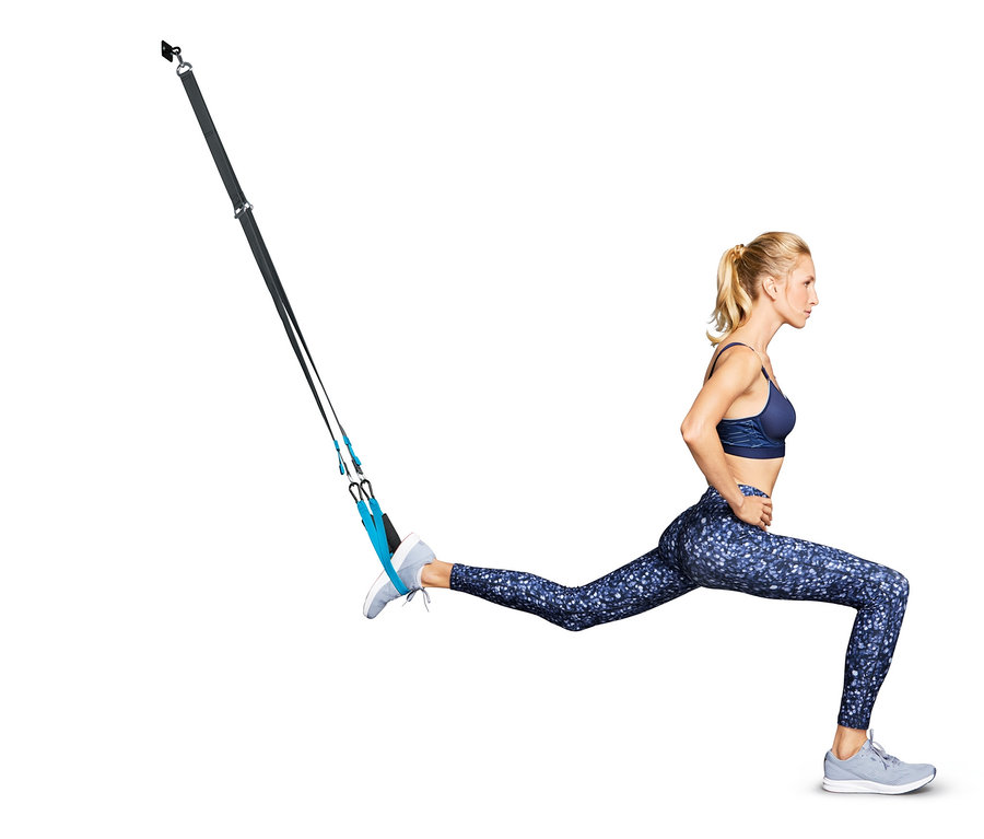 Žena cvičí výpad pomocí závěsného posilovacího systému.
