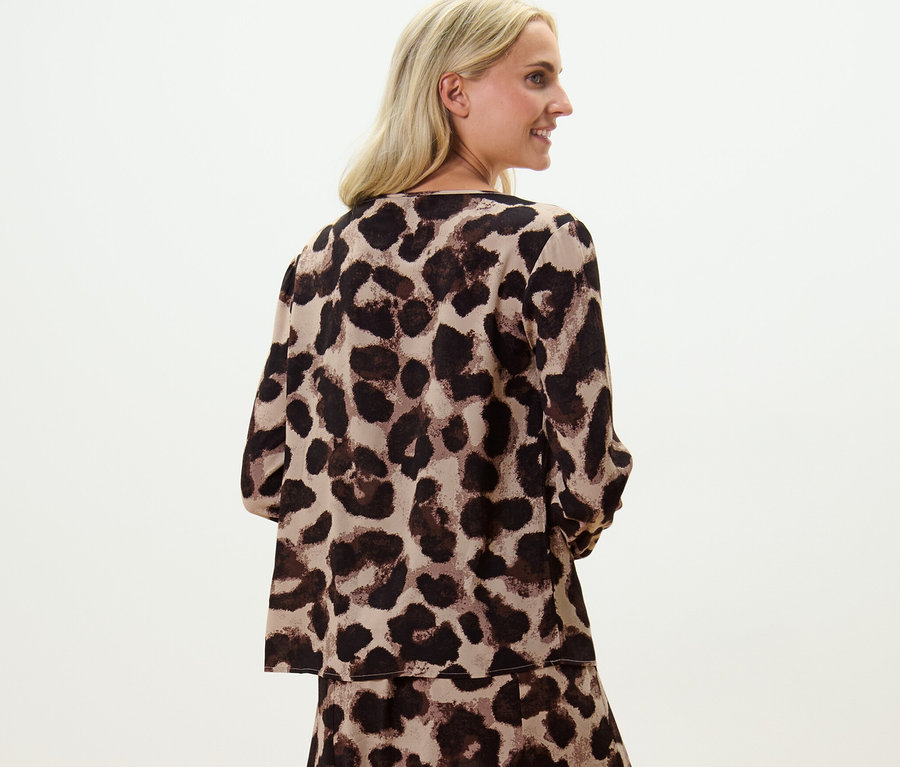 Blonďatá žena pózuje v halence s potiskem.