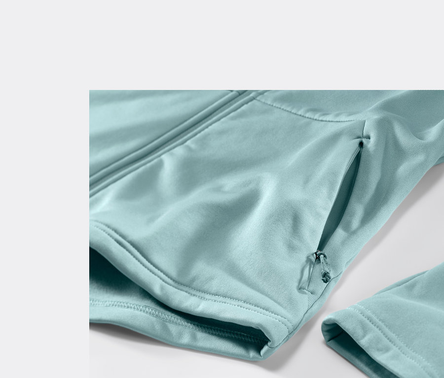 Detail světle modré termobundy s kapsou na zip a rukávem.